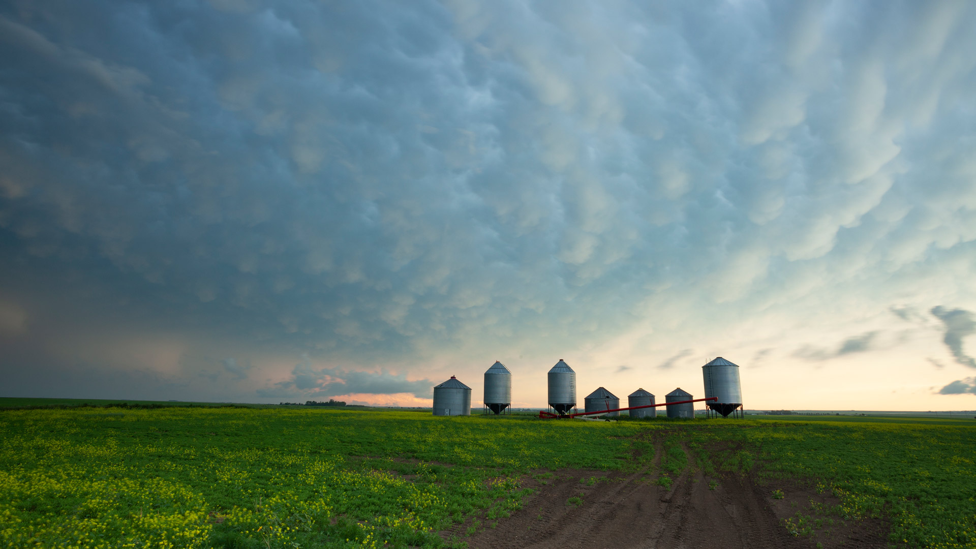A prairie storm gathers over grain silos in Saskatchewan (© mysticenergy/Getty Images)